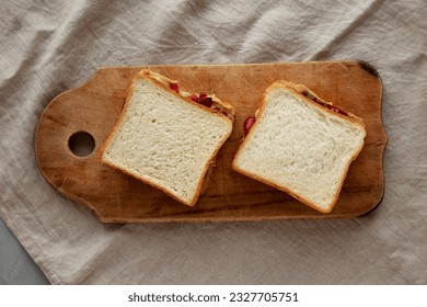 Homemade Peanut Butter and Jelly Sandwich on a rustic wooden board, top view. - Powered by Shutterstock