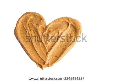 Homemade peanut butter and patterned sandwich isolated on white background. The concept of love for nuts. Favorite breakfast. Nuts in the shape of a heart