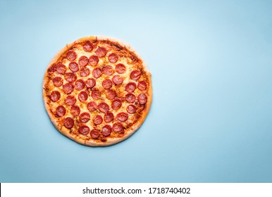 Homemade Pepperoni Pizza Above View. Whole Pizza On A Blue Background. Fresh Home-baked Pizza With Mozzarella And Pepperoni