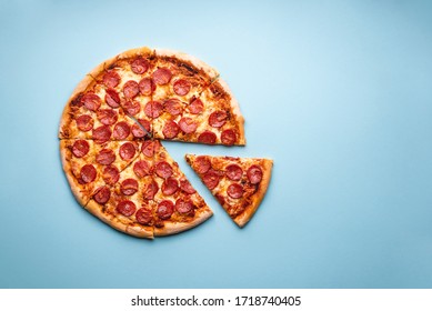 Homemade Pepperoni Pizza On Blue Background Above View. Hot Pizza Sliced. Homemade Pizza With Pepperoni And Mozzarella