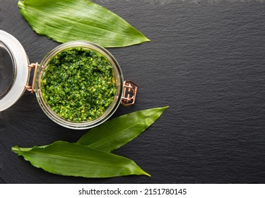 Homemade Pesto Sauce Made With Allium Ursinum Leaves, Known As Wild Garlic, Ramsons, Buckrams, Broad-leaved Garlic, Wood Garlic, Bear Leek Or Bear's Garlic. Lot Of Copy Space On Black Stone Texture.