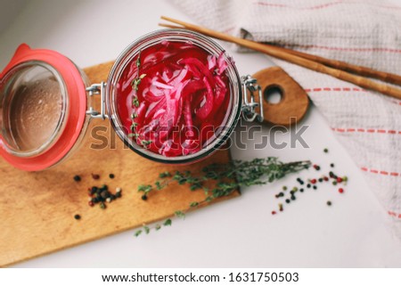 homemade pickled red onions in a glass jar
pickled onions and thyme on a light background next to chopsticks
