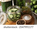 Homemade pickles. Fresh cucumbers in jar, dill and spices on table, closeup