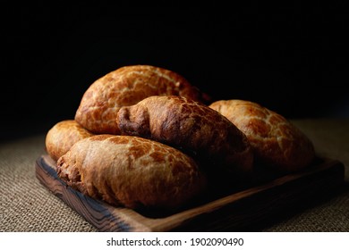 Homemade pies made from yeast dough, on a wooden board, on sacking - Shutterstock ID 1902090490