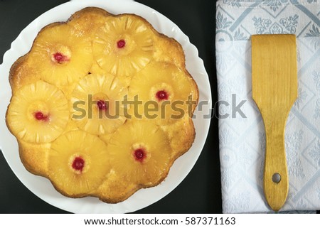 Homemade pineapple upside down cake on black background