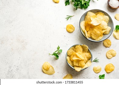 Homemade potato chips in bowls. Crispy potato chips on white background, top view, copy space.