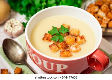 Homemade Potato Cream Soup With Croutons And Parsley In Red Bowl On Table