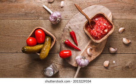 Homemade Preparations, Fermentation. Pickled Cucumbers And Tomatoes, In A Wooden Bowl On A Table Made Of Boards. Top View, No People, Horizontal Orientation, Copy Space, No Face