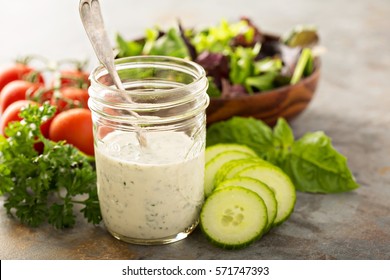 Homemade ranch dressing in a mason jar with fresh vegetables - Shutterstock ID 571747393