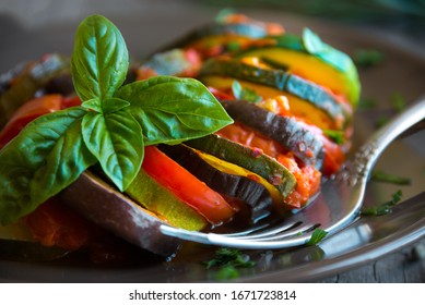 Homemade Ratatouille Made With Sliced Vegetables (zucchini, Tomatoes, Eggplant) On Dark Plate. Delicious Vegan Dish