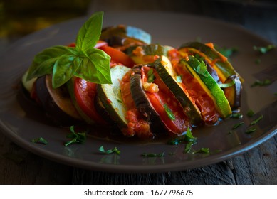 Homemade Ratatouille Made With Sliced Vegetables (zucchini, Tomatoes, Eggplant) On Dark Plate. Delicious Vegan Dish