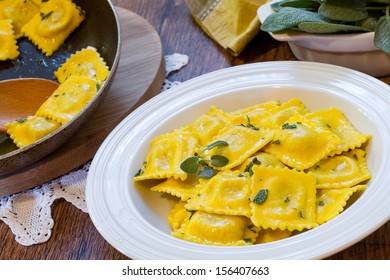 homemade ravioli pasta with sage butter sauce  on wooden table wirh accessories