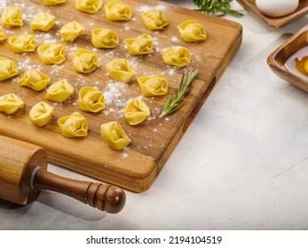 Homemade Raw Dumplings On A Wooden Cutting Board Are Waiting To Be Cooked. Isolated On White Background. There Are No People In The Photo. There Is Free Space To Insert.