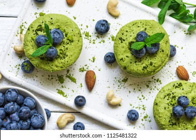 Homemade Raw Matcha Powder Cakes With Fresh Berries, Mint, Nuts. Healthy Vegan Food Concept. Top View