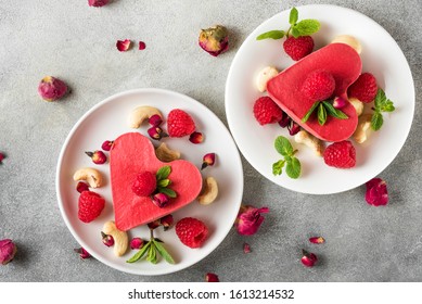 Homemade Raw Vegan Heart Shaped Cakes With Fresh Raspberries, Mint, Dried Rose Flowers And Cashew. Valentines Day Dessert. Healthy Vegan Food Concept. Top View