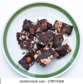 Homemade Rocky Road Chocolate On White Plate With Green Trim On White Background