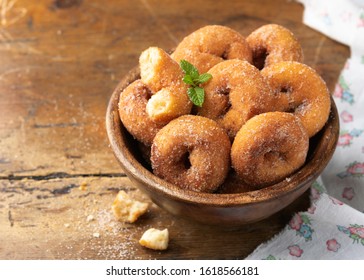 Homemade rosquillas, traditional anise donuts from Spain, typically eaten in Easter, on a rustic wooden table, space for text. Still life.