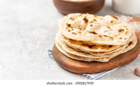 Homemade Roti Chapati Flatbread on gray concrete background. Freshly baked indian flatbread. Copy space for text.