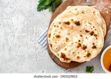 Homemade Roti Chapati Flatbread  on gray concrete background top view. Freshly baked indian flatbread. Copy space for text.