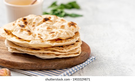Homemade Roti Chapati Flatbread on gray concrete background. Freshly baked indian flatbread. Copy space for text.