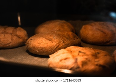 Homemade Round Brown Rye Fletbread Baking In Electric Oven. Production Oven At The Bakery. Fresh And Crunchy Home Made Bread. View Through Glass Oven Door. Selective Focus