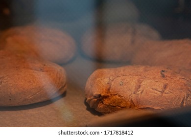 Homemade Round Brown Rye Fletbread Baking In Electric Oven. Production Oven At The Bakery. Fresh And Crunchy Home Made Bread. View Through Glass Oven Door. Selective Focus