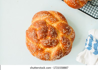 Homemade round challah with sesame seeds. Traditional freshly baked jewish pastry. Top view.