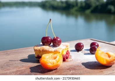 Homemade rustic cherrypie pie slice on wooden board over river Tisa.