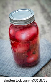 Homemade rustic organic pickled beet eggs on wooden table
