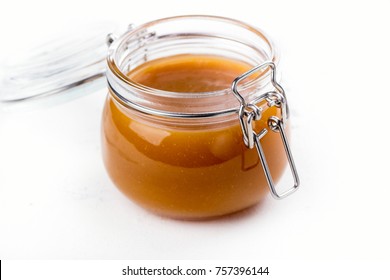 Homemade Salted Caramel Sauce In A Glass Jar On Stone Table