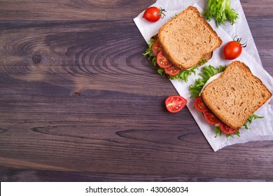 Homemade Sandwich With Egg, Salad And Tomatoes On Crispy Slice Of Rye Bread On A Dark Wooden Background. Top View With Copyspace