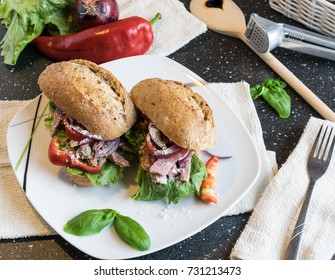 Homemade sandwich with pieces of grilled pork, vegetables and mayonnaise