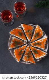 Homemade sandwiches with red caviar on rye bread on a plate on dark gray background, Festive snack, Top view