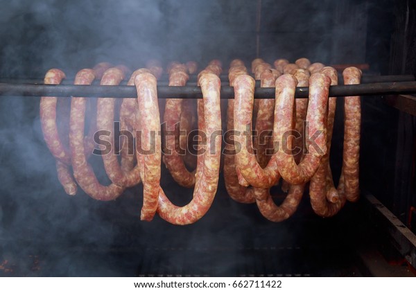 Homemade sausages in a traditional smoker smoked\
sausage in Smokers