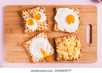 Homemade scrambled egg, poached egg, fried egg, boiled egg on toast on a board top view