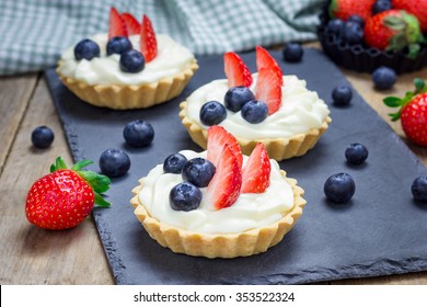 Homemade shortbread tartlets with custard cream, strawberry and blueberry - Powered by Shutterstock