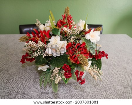 A homemade silk flower center piece arrangement on a dining table.