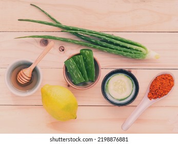 Homemade Skin Care And Body Scrub With Natural Ingredients Aloe Vera ,lemon,cucumber ,tumeric Powder And Honey Set Up On On Wooden Background.