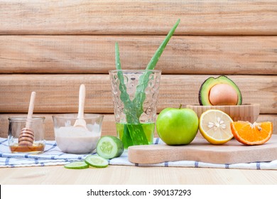 Homemade skin care and body scrub with natural ingredients avocado ,aloe vera ,lemon,cucumber ,orange ,apple, lime and honey set up on on  wooden background.