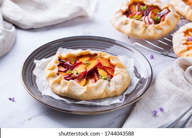 Homemade Small Nectarine, Peach, Apricot Galette, Tart, Seasonal Summer Open Pie With Aromatic Herbs. Healthy And Tasty Bakery Product, Dessert With Ripe Fruits.