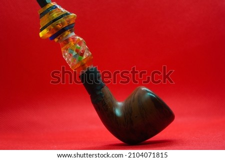Homemade smoking pipe on a red background