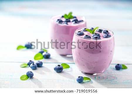 Homemade  smoothie  with fresh  blueberries on a rustic turquoise background