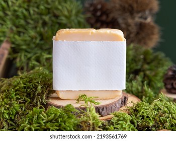 Homemade Soap Bar With Blank Label On Wooden Piece Near Green Moss, Close Up Copy Space. Natural Cosmetic Mockup. Everyday Skincare Beauty Routine With Facial Cleanser