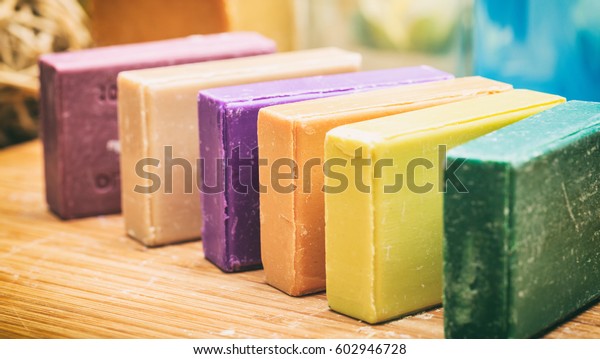 Homemade soaps. Variety of colorful handmade\
soap bars on wooden\
background