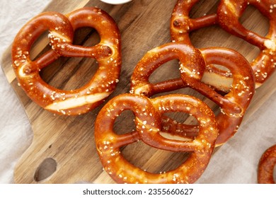 Homemade Soft Bavarian Pretzels with Mustard on a wooden board, top view.