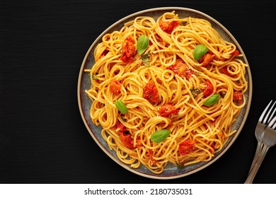 Homemade Spaghetti Pasta With Fresh Tomato Sauce On A Plate On A Black Surface, Top View. Flat Lay, Overhead, From Above. Copy Space.