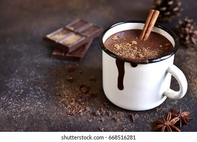 Homemade spicy hot chocolate with cinnamon in enamel mug on a slate,stone or concrete background. - Shutterstock ID 668516281