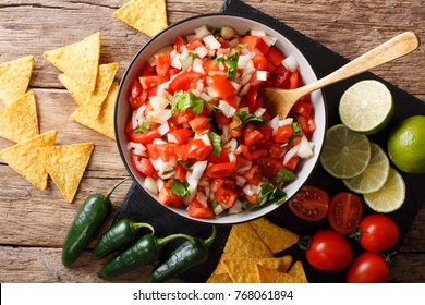 Homemade Spicy Pico De Gallo Close-up In A Bowl And Nachos On The Table. Horizontal Top View From Above
