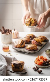 Homemade Spicy Pumpkin Muffins Or Cupcakes With Chocolate On A Metal Rack With Woman Hands In The Background. Autumn Dessert. Selective Focus