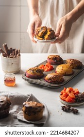 Homemade Spicy Pumpkin Muffins Or Cupcakes With Chocolate On A Metal Rack With Woman Hands In The Background. Autumn Dessert. Selective Focus